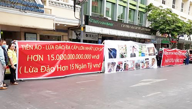 
Người dân tụ tập trước cổng công ty M.T để phản đối công ty tiền ảo lừa đảo 15 nghìn tỉ của khách hàng. (ảnh Huy Hùng).
