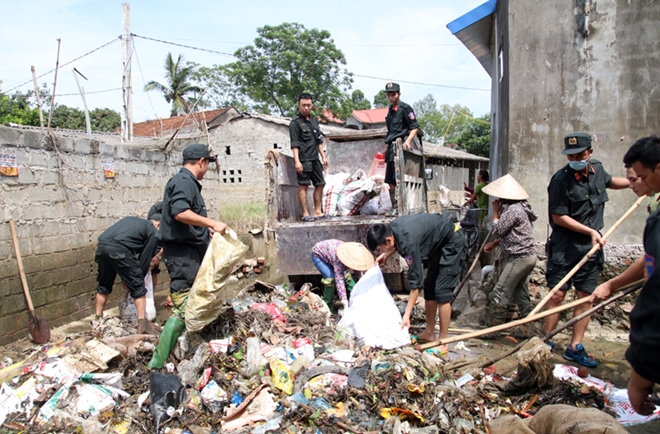 Cảnh sát cơ động giúp dân dọn dẹp vệ sinh môi trường sau lũ