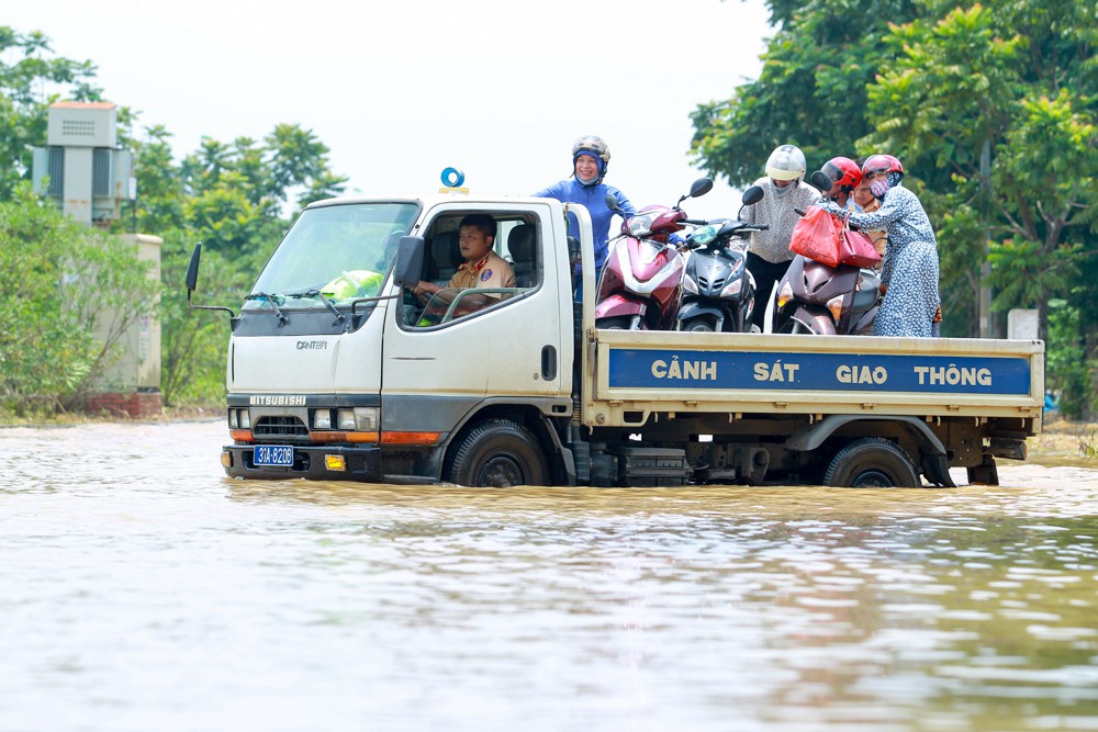 Cảnh sát giao thông Hà Nội dùng xe tải chở người dân qua điểm ngập