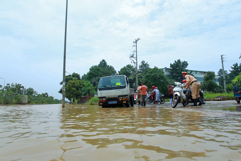 Cảnh sát giao thông Hà Nội dùng xe tải chở người dân qua điểm ngập